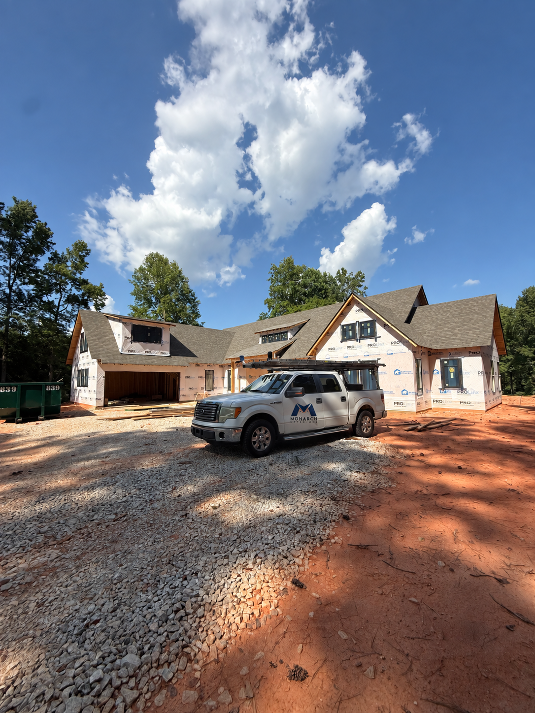 Monarch Exteriors truck with its logo at a residential roofing jobsite